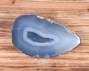 Partially polished blue lace agate geode with crystaline druzy center on wooden vintage background
