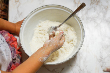 Mother and kids hands making dough on the table