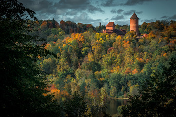Naklejka premium Picturesque view on valley of Gaujas national park. Trees changing colors in foothills. Colorful Autumn day at city Sigulda in Latvia. 