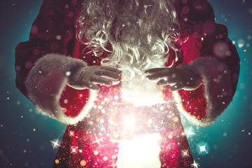 Santa Claus with magic Christmas lights