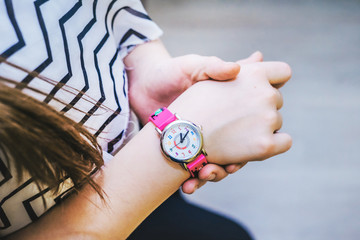 Girl looks time on her pink kidswatch.