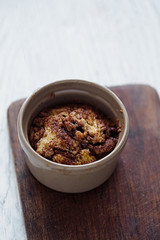 Baked muffin cake with cinnamon and brown sugar in a ceramic cake. White rustic wooden table