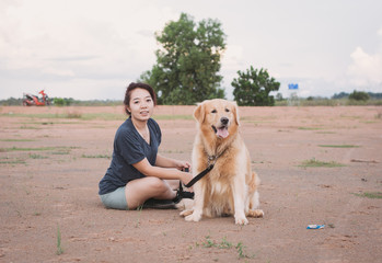 woman with her golden retriever dog playing outdoors