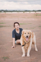 woman with her golden retriever dog playing outdoors