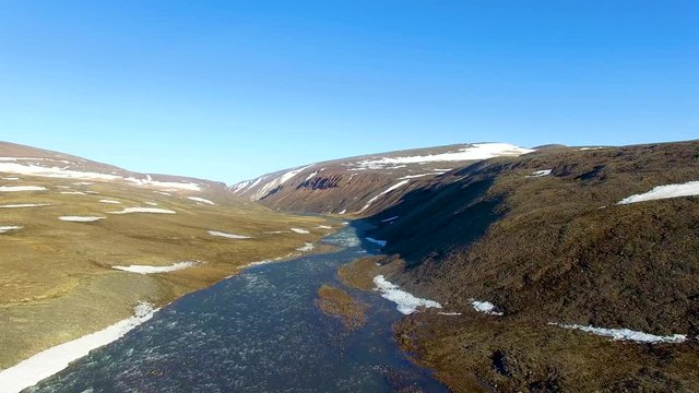 Aerial shot ascending above a small river in the arctic