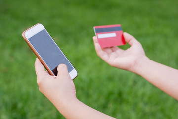 woman hands holding credit card and using cell, smart phone for online shopping