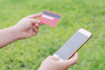 woman hands holding credit card and using cell, smart phone for online shopping