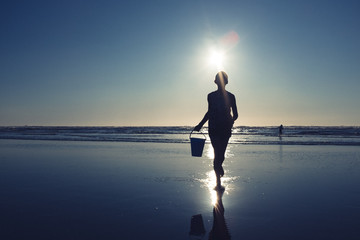 Young female silhouette on beach
