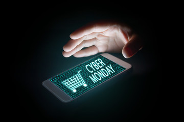 woman hands holding smart phone with cyber monday text and cart icon on virtual screens on...