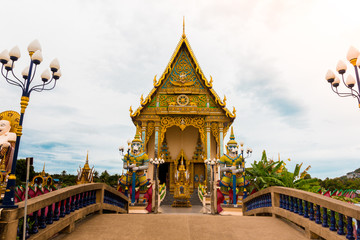 Fototapeta na wymiar Buddhist temple with crossed bridge and giant statue at Wat Plai Lam, Koh Samui, Thailand.