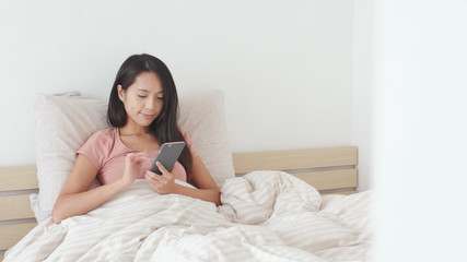 Obraz na płótnie Canvas Woman use of mobile phone on bed