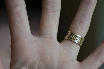 left hand with gold wedding ring on finger