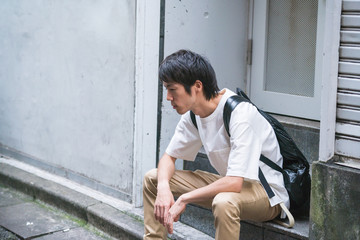 Obraz premium 階段に腰掛ける男性
