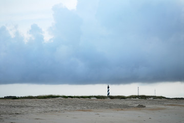 lighthouse in beach area under storm cloud