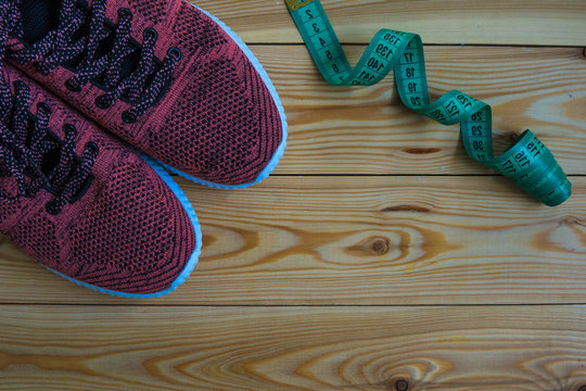 Sneakers and centimeter top view. Healthy and active lifestyles. Wooden background.