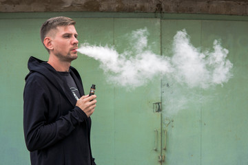 Man with vape. Young man smoking an electronic cigarette