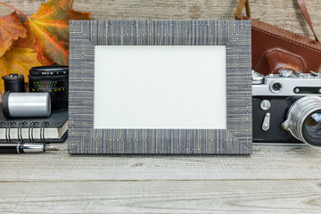 vintage camera, negative films, lenses and frame on grunge wooden background with colorful dried...