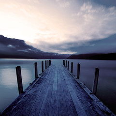 Panele Szklane Podświetlane  Molo dla łodzi i spokojne jezioro o wschodzie słońca, Nowa Zelandia.