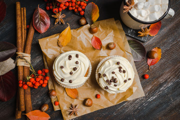 Cupcakes with autumn decorations on the rustic wooden background. Shallow depth of field.