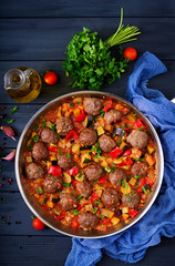 Meatballs in tomato sauce and vegetables in stew-pan