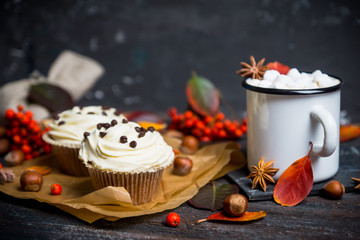 Cupcakes with autumn decorations on the rustic wooden background. Shallow depth of field.