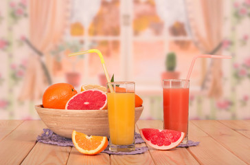 Bowl of citrus fruit, glasses of orange and grapefruit juices