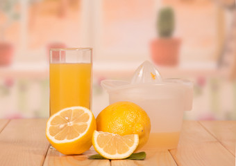 Whole ripe lemon, half, slice, glass of juice and juicer