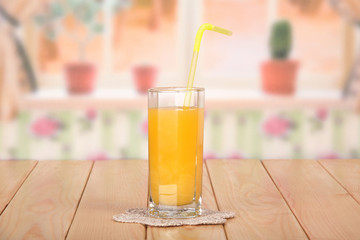 Glass of fresh orange juice with straw and lace napkin