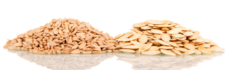Heap of unpeeled pumpkin seeds and peeled sunflower seeds isolated on white.