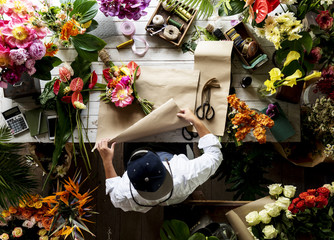 Florist making a flower arrangement in a flower shop - obrazy, fototapety, plakaty