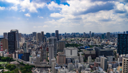Fototapeta premium Beautiful city skyline of Downtown Tokyo, Among crowded skyscrapers under blue sunny sky in Tokyo, Japan. Aerial view of busy Tokyo City. 10 October 2017