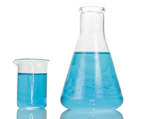 A chemical flask and beaker with blue liquids close-up isolated on white background.