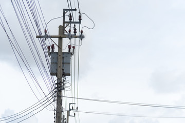 Energy and technology: electrical post by the road with power line cables, transformers and phone...