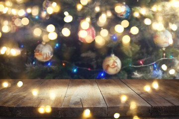Empty table in front of christmas tree with decorations background. For product display montage