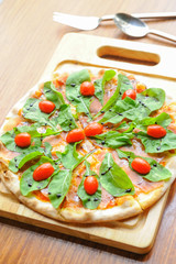 Pizza with cheese, salmon and rocket salad