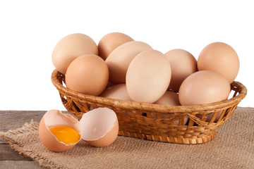 eggs on a wooden table in a wicker basket on a white background