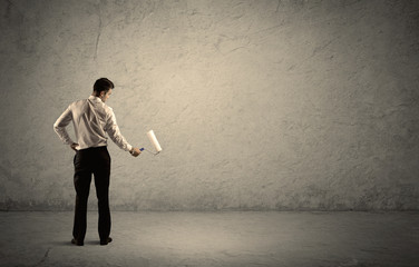 Obraz premium Salesman with roller standing at empty wall