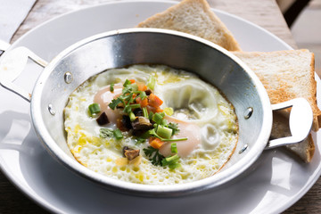 Pan of fried eggs with bread for breakfast