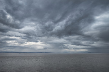 Fototapeta na wymiar Landscape image of view out to sea with storm cloud sky overhead