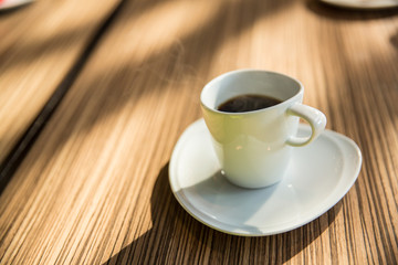 Coffee cup on table with hot stream or smoke in cafe