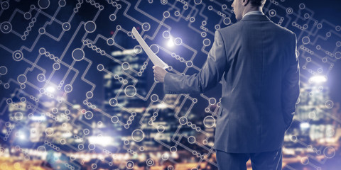 Rear view of businessman against night cityscape background and 