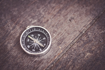 Travel and business direction concept, vintage color, compass on wooden floor.copy space on the right for text.