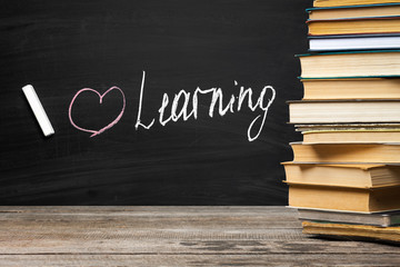 School blackboard with pile of books