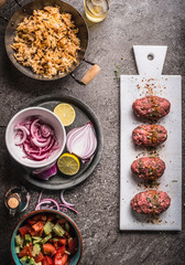 Meat balls cooking preparation with rice dish and salad on rustic kitchen table background, top view