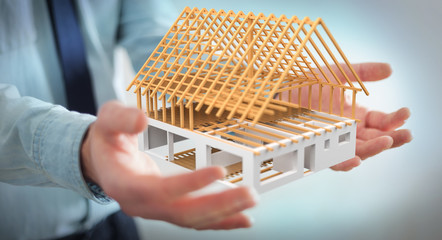 Businessman holding 3D rendering unfinished plan house in his hand
