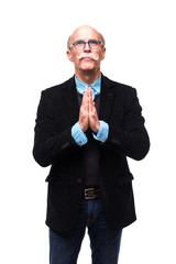 Portrait of aged elegant man making pray gesture looking up wearing suit isolated on white background