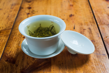 White cup of jasmine tea on a wood table in China