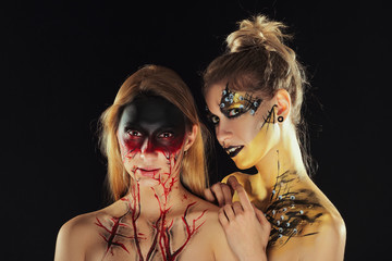 Two girls with mystic makeup. Halloween horror ladies.