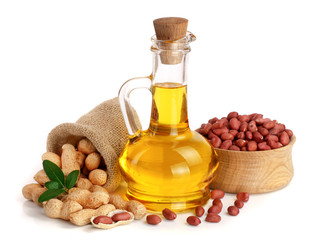 peanut oil in a glass bottle with peanuts in bowl