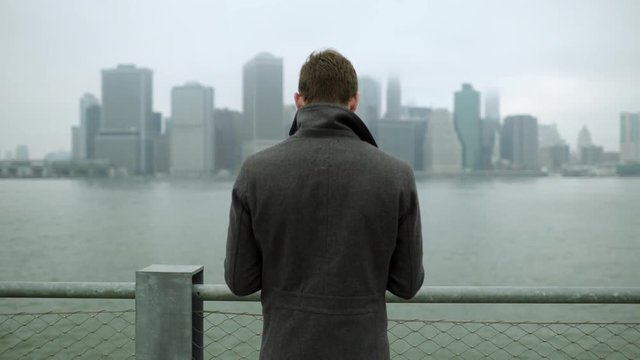 Young man watching at Manhattan while standing near Hudson river